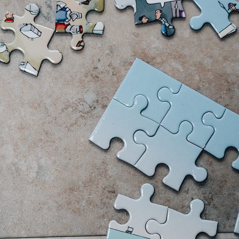 white jigsaw puzzle pieces on brown marble table